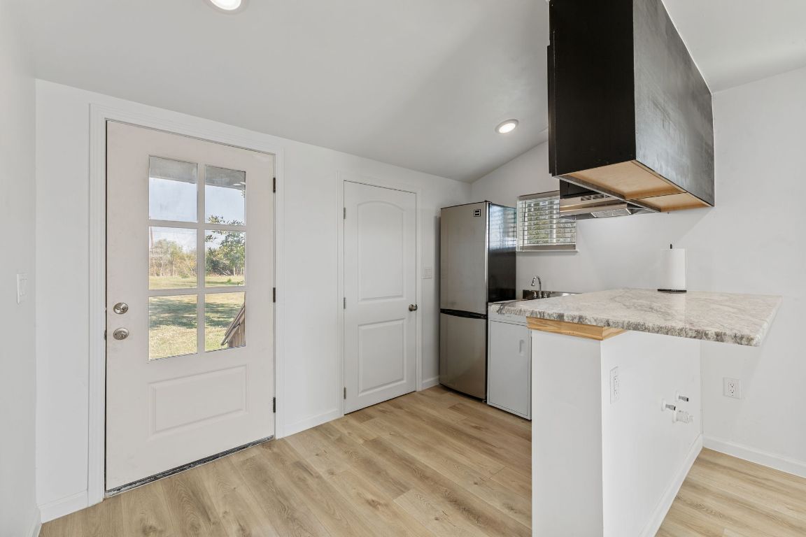 603 East 3rd Street Taylor, TX 76574 - Photo 17 of 30 a kitchen with a refrigerator a stove and a microwave oven
