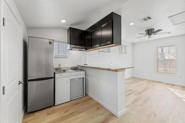 a kitchen with stainless steel appliances a refrigerator microwave and sink
