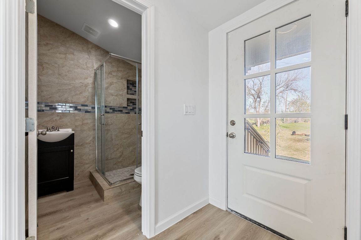 603 East 3rd Street Taylor, TX 76574 - Photo 22 of 30 a bathroom with a glass shower door