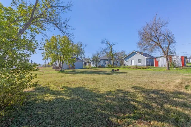 a view of an house with backyard space and tree