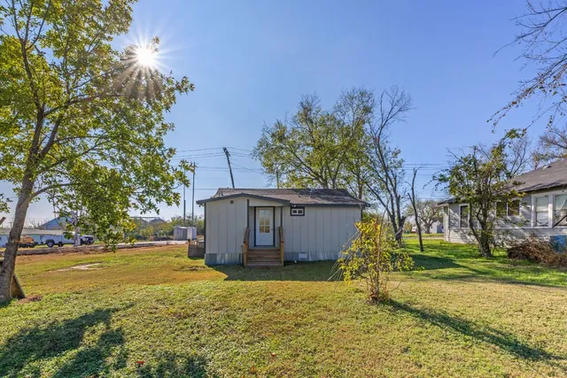 a view of a house with backyard and tree