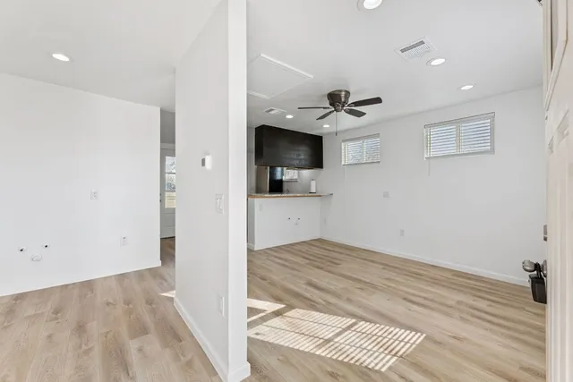 wooden floor in an empty room with a kitchen