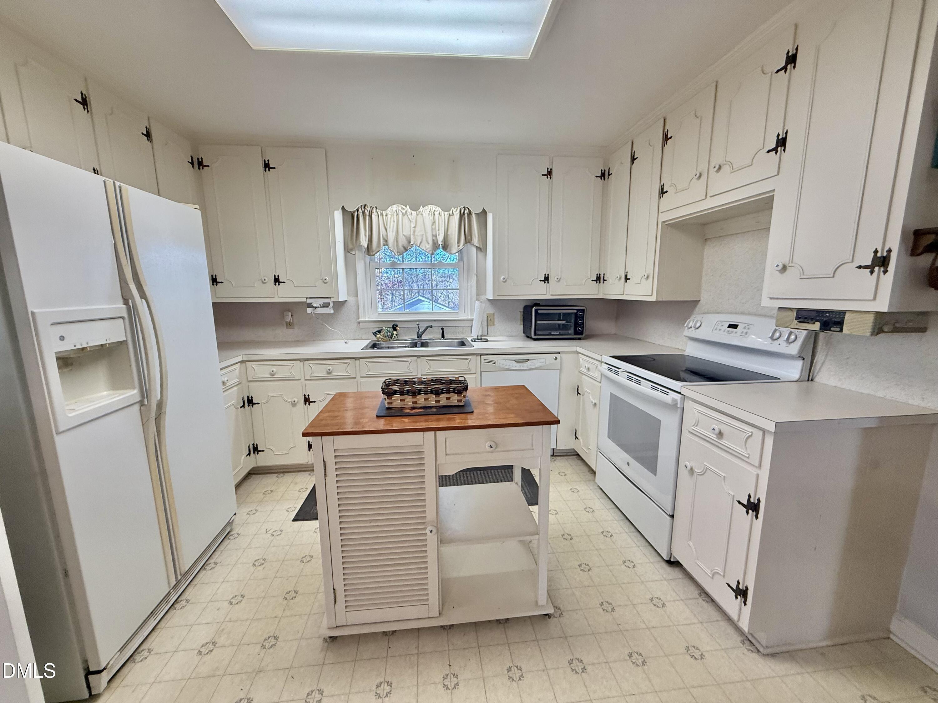 424 Tanglewood Circle Roxboro, NC 27573 - Photo 16 of 47 a kitchen with stainless steel appliances white cabinets and a refrigerator