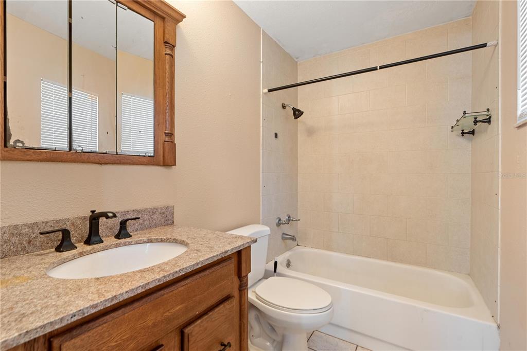 4008 Windswept Avenue Spring Hill, FL 34606 - Photo 19 of 32 a bathroom with a granite countertop sink toilet and shower