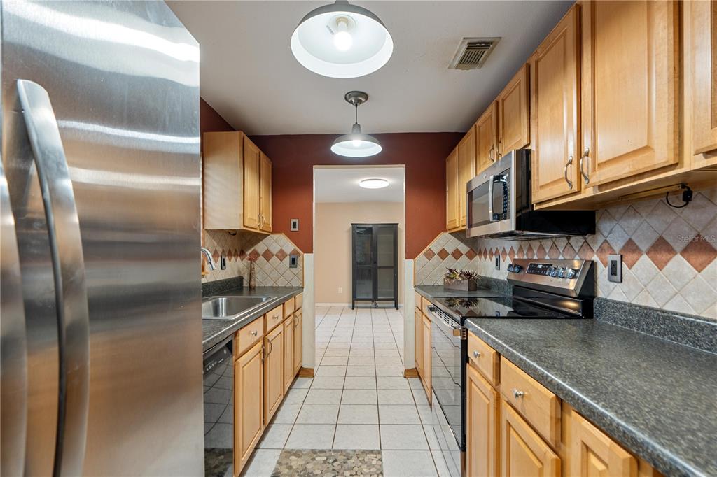 4008 Windswept Avenue Spring Hill, FL 34606 - Photo 9 of 32 a kitchen with stainless steel appliances granite countertop a sink and a refrigerator