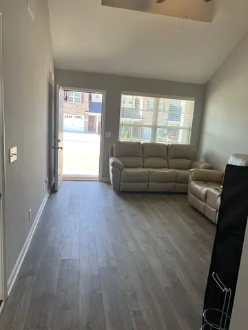 a living room with furniture and a hard wood floor