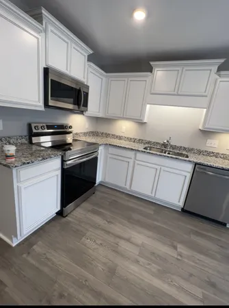 a view of a kitchen with a sink cabinets and wooden floor