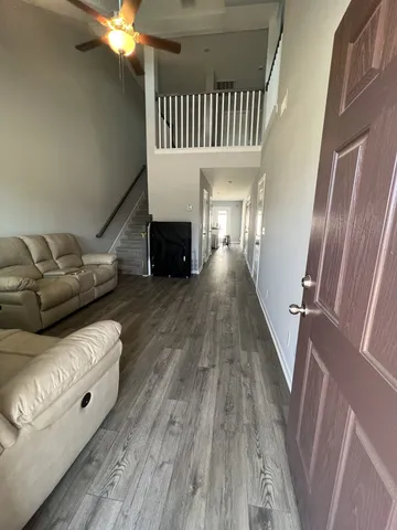 a view of a livingroom with wooden floor and staircase