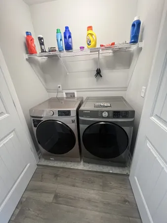 a utility room with a sink and wooden floor