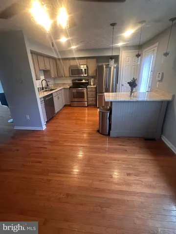 a kitchen with stainless steel appliances a refrigerator and a stove top oven