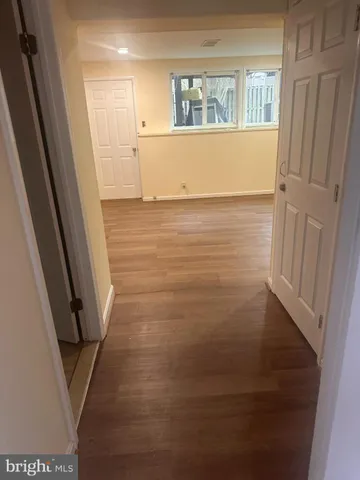 a view of wooden floor in an empty room with a window
