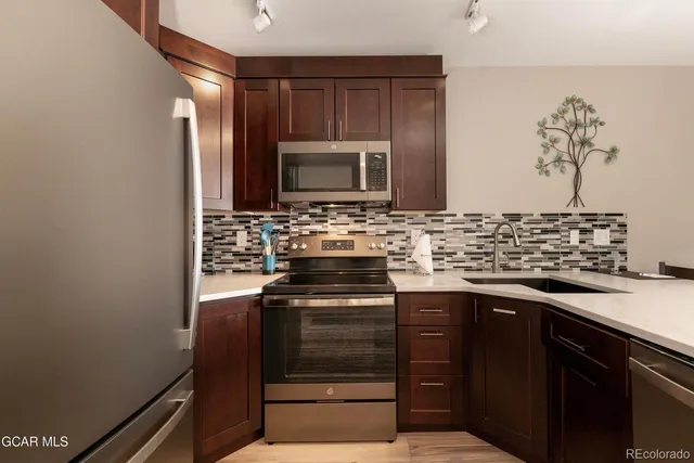 a kitchen with stainless steel appliances a stove and a sink