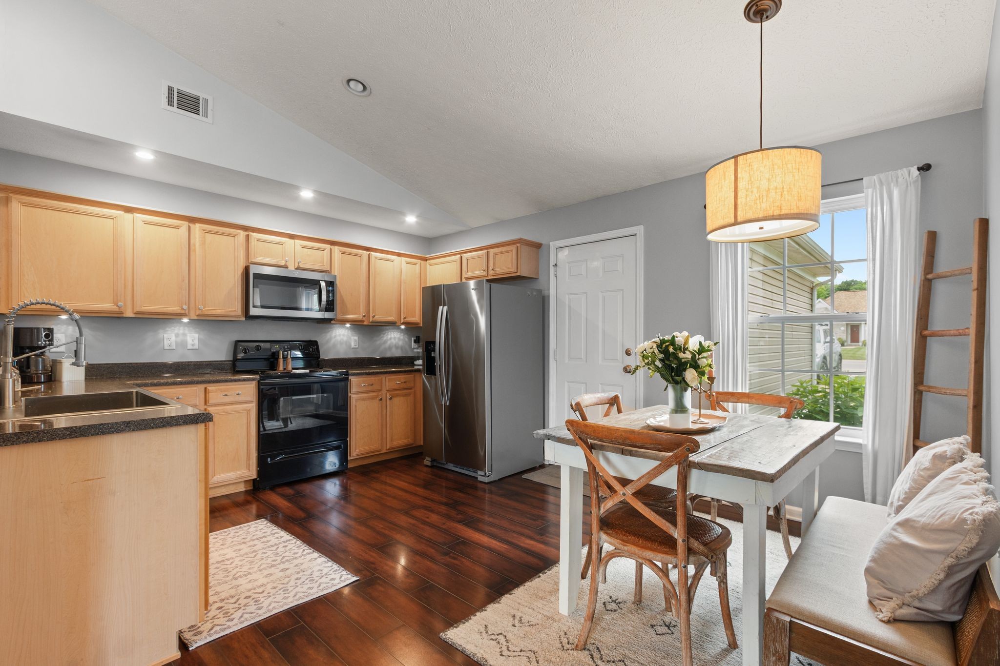 3003 Pandell Court Spring Hill, TN 37174 - Photo 6 of 22 a kitchen with stainless steel appliances granite countertop a refrigerator a stove a sink a dining table and chairs with wooden floor