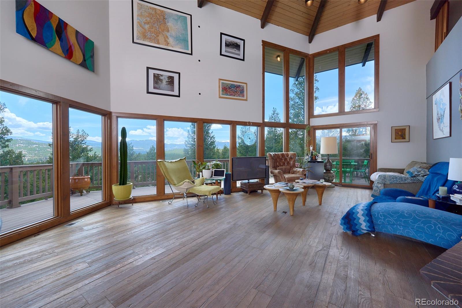 918 Ridge Road Nederland, CO 80466 - Photo 8 of 35 a view of a living room filled with furniture and floor to ceiling windows