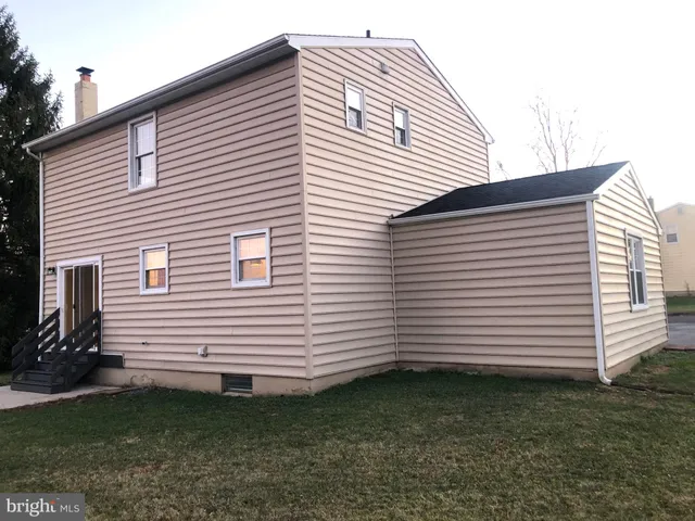 a view of a white house with a small backyard