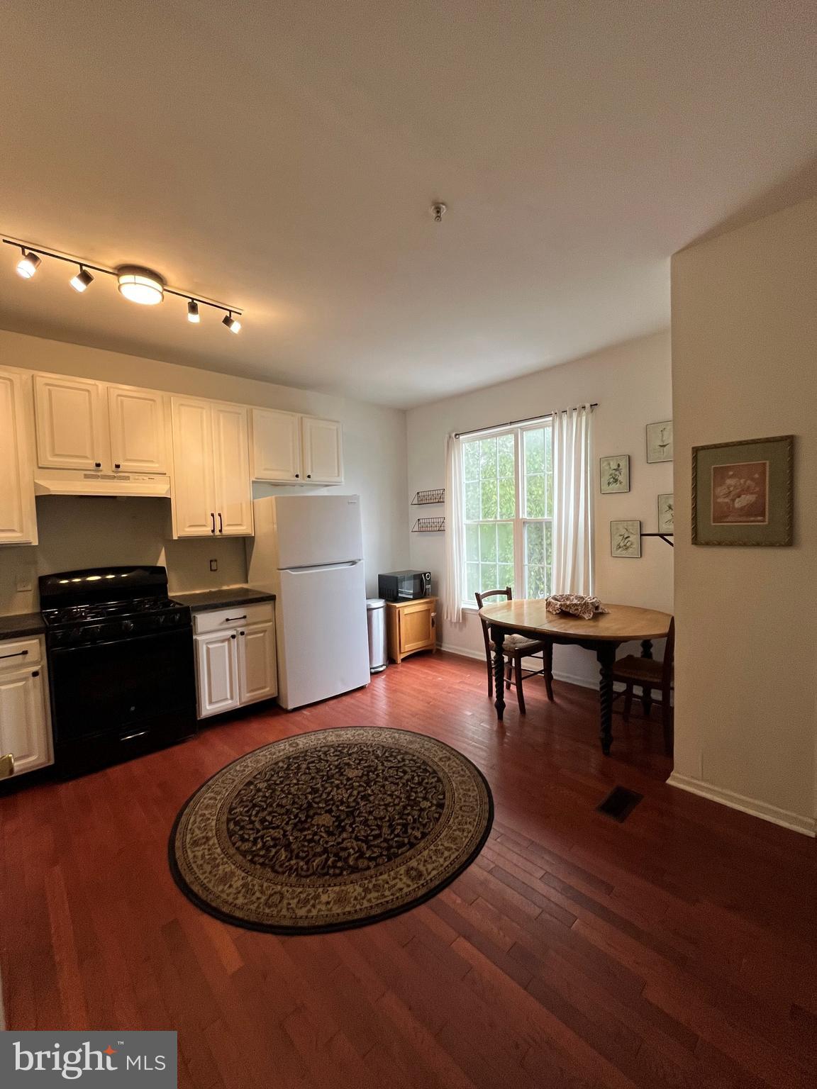 79 Mule Deer Court Elkton, MD 21921 - Photo 7 of 21 a kitchen with stainless steel appliances granite countertop a stove a refrigerator a sink a dining table and chairs with wooden floor