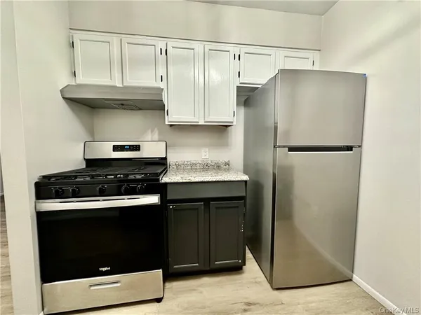 a kitchen with stainless steel appliances granite countertop a refrigerator and a stove