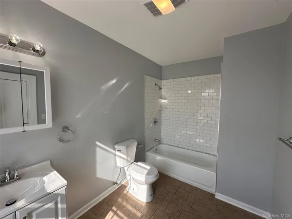 a bathroom with a granite countertop toilet a sink and shower