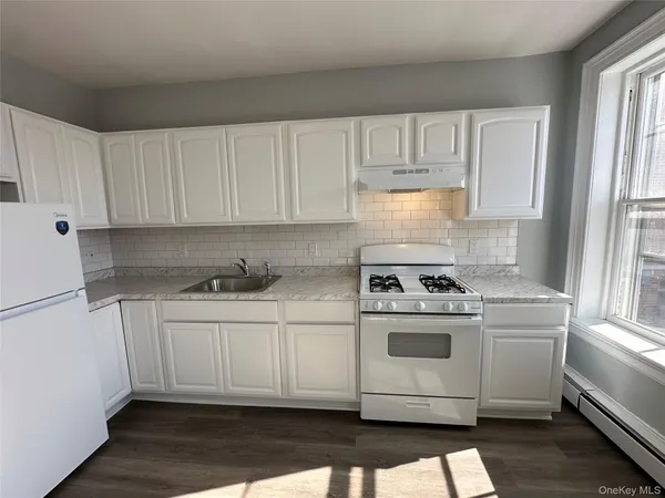 a kitchen with granite countertop white cabinets and white appliances