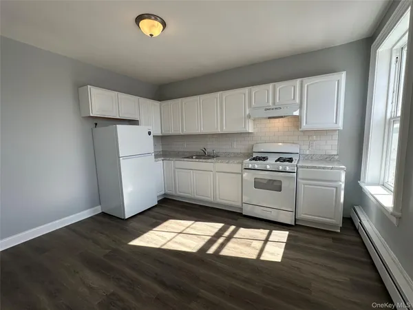 a kitchen with granite countertop white cabinets and white appliances