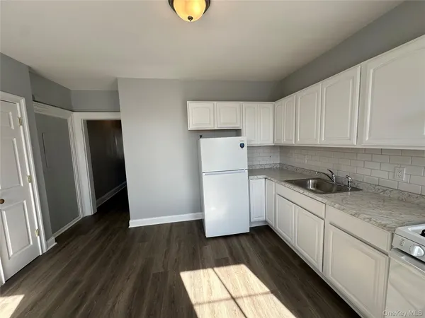 a kitchen with a refrigerator and a stove top oven