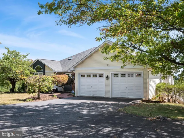 a view of an empty room with window and hardwood floor