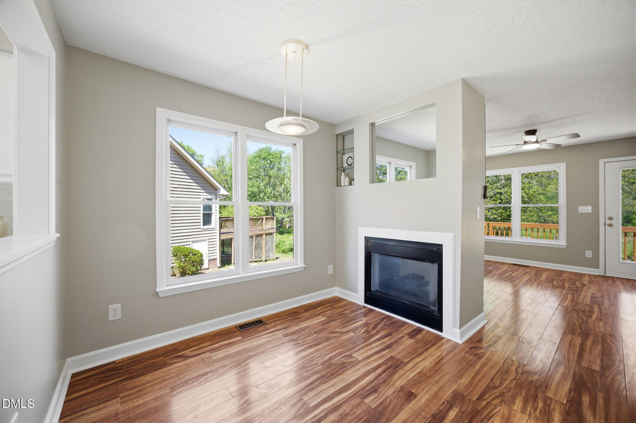 1626 Oakland Hills Way Raleigh, NC 27604 - Photo 10 of 25 an empty room with windows a fireplace and wooden floor
