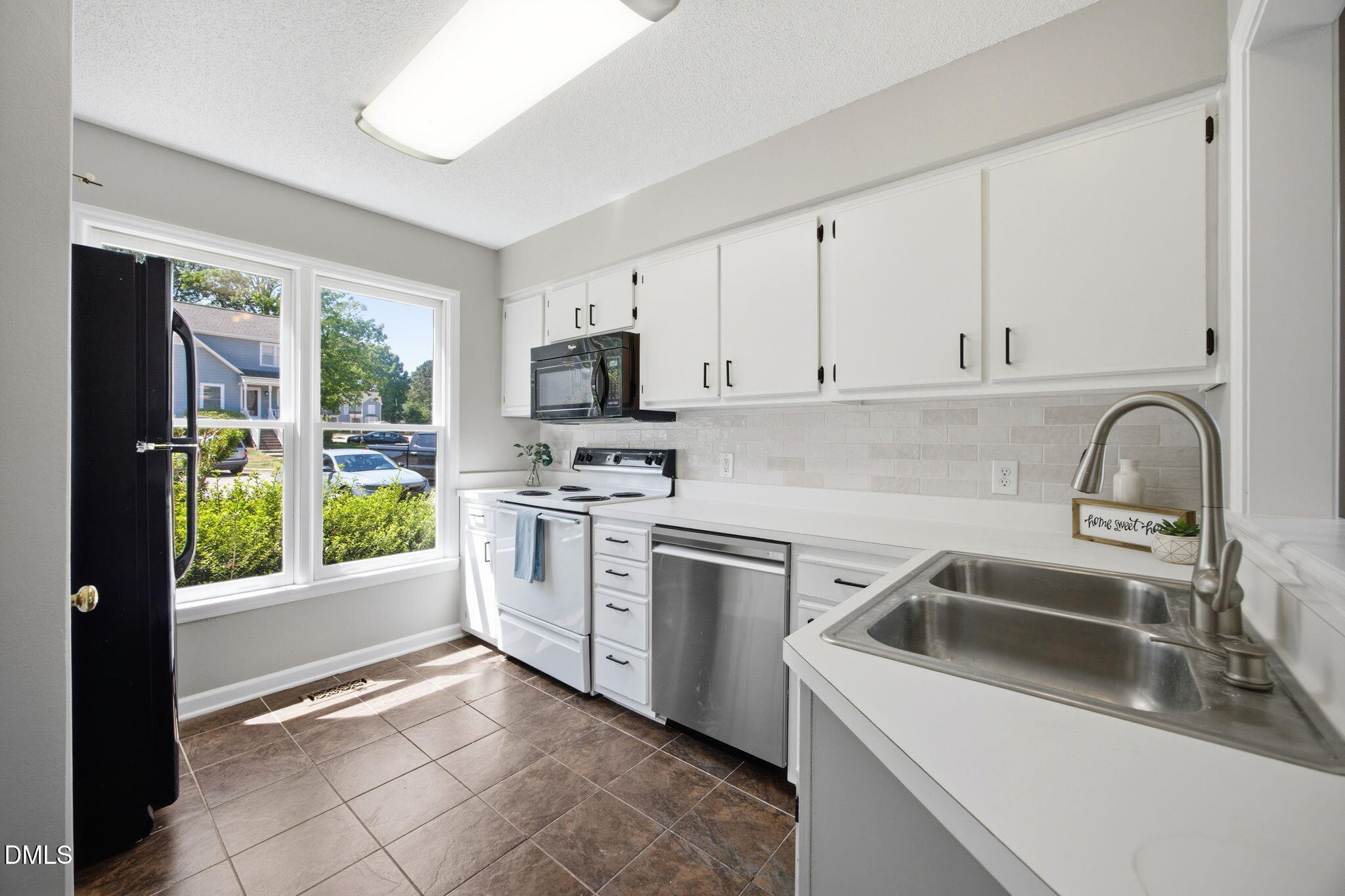 1626 Oakland Hills Way Raleigh, NC 27604 - Photo 8 of 25 a kitchen with white cabinets a sink and appliances
