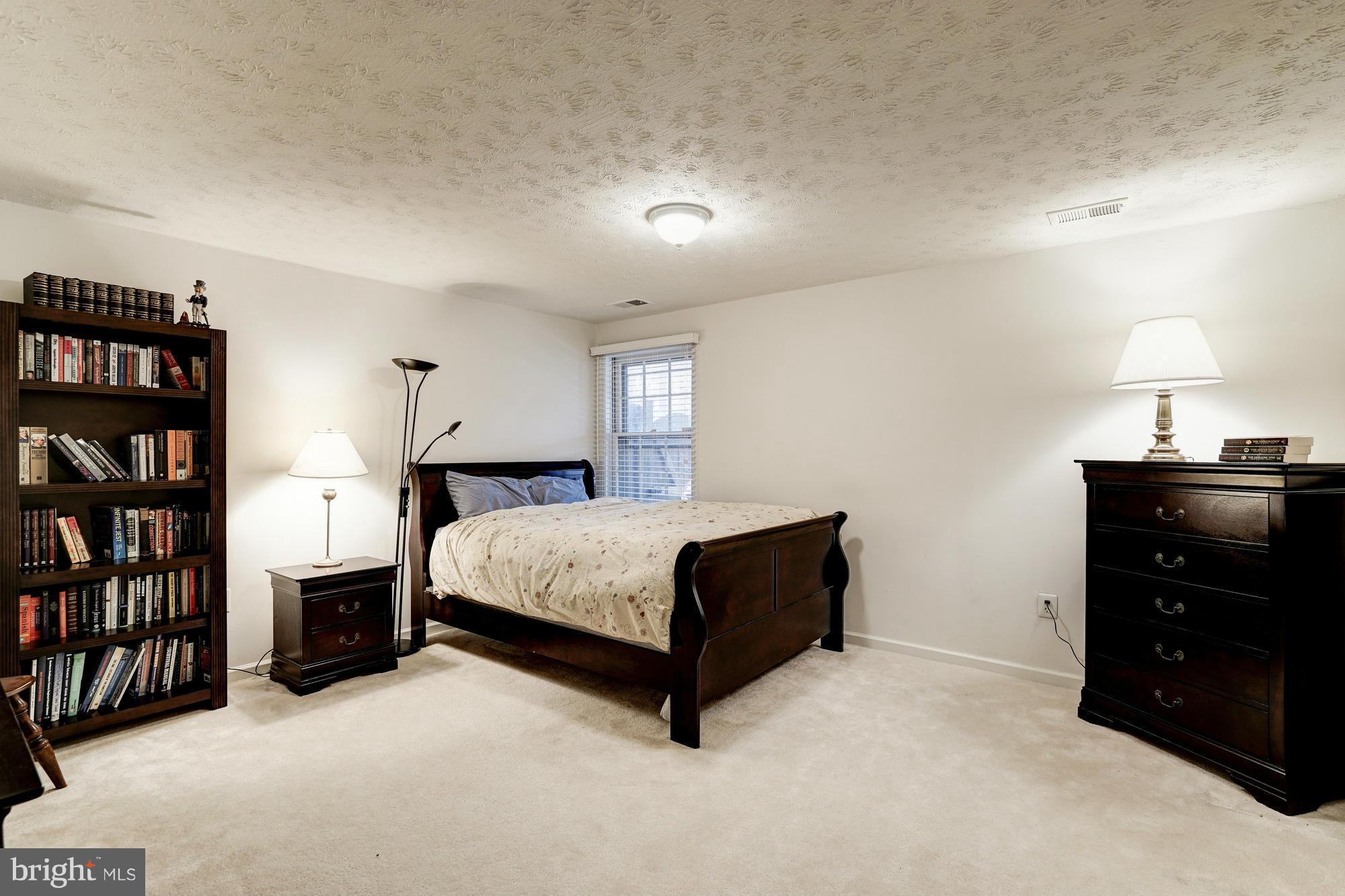 7415 Ridge Oak Court Springfield, VA 22153 - Photo 18 of 30 a bedroom with a bed and a book shelf