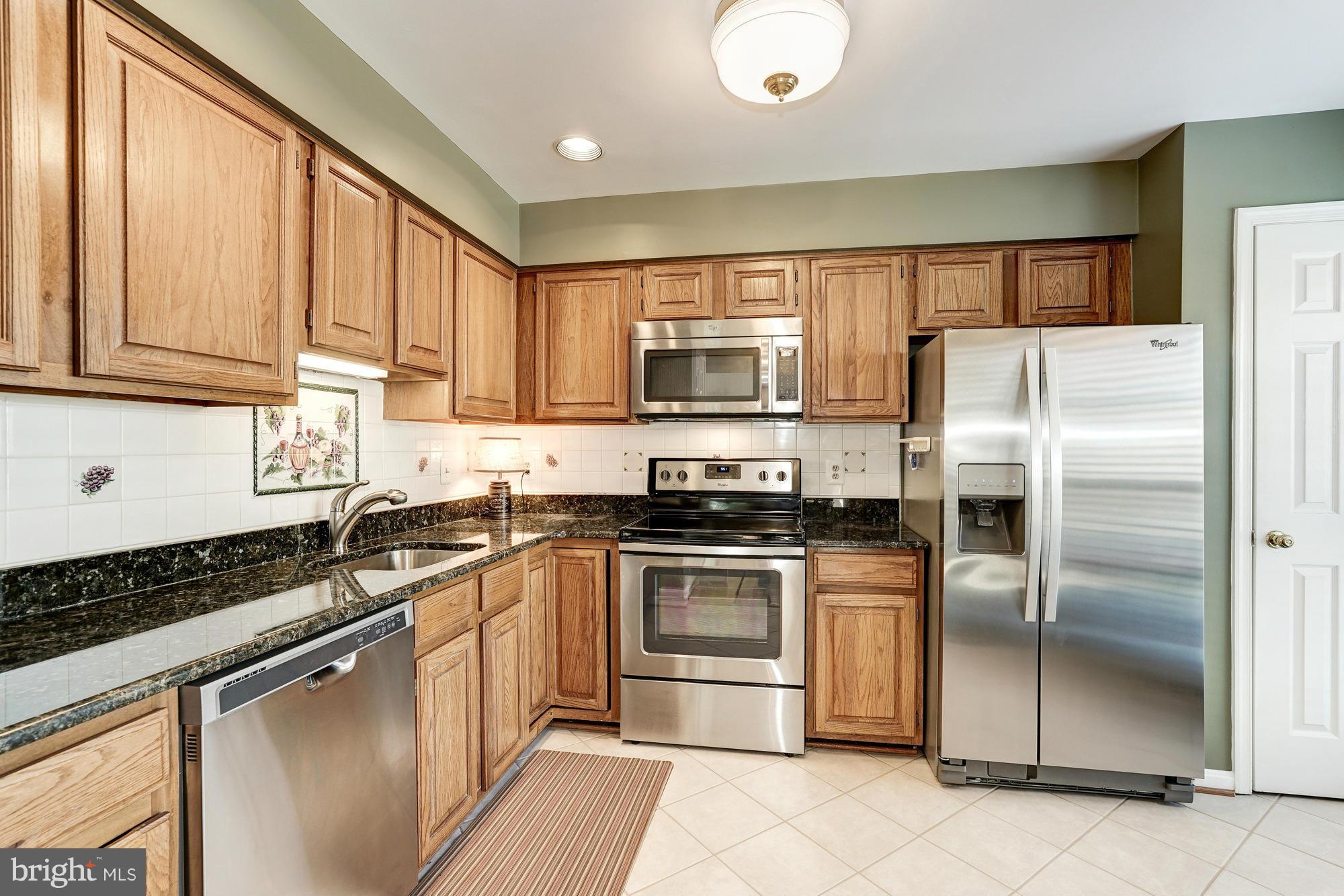 7415 Ridge Oak Court Springfield, VA 22153 - Photo 4 of 30 a kitchen with stainless steel appliances granite countertop a stove top oven a refrigerator and a sink