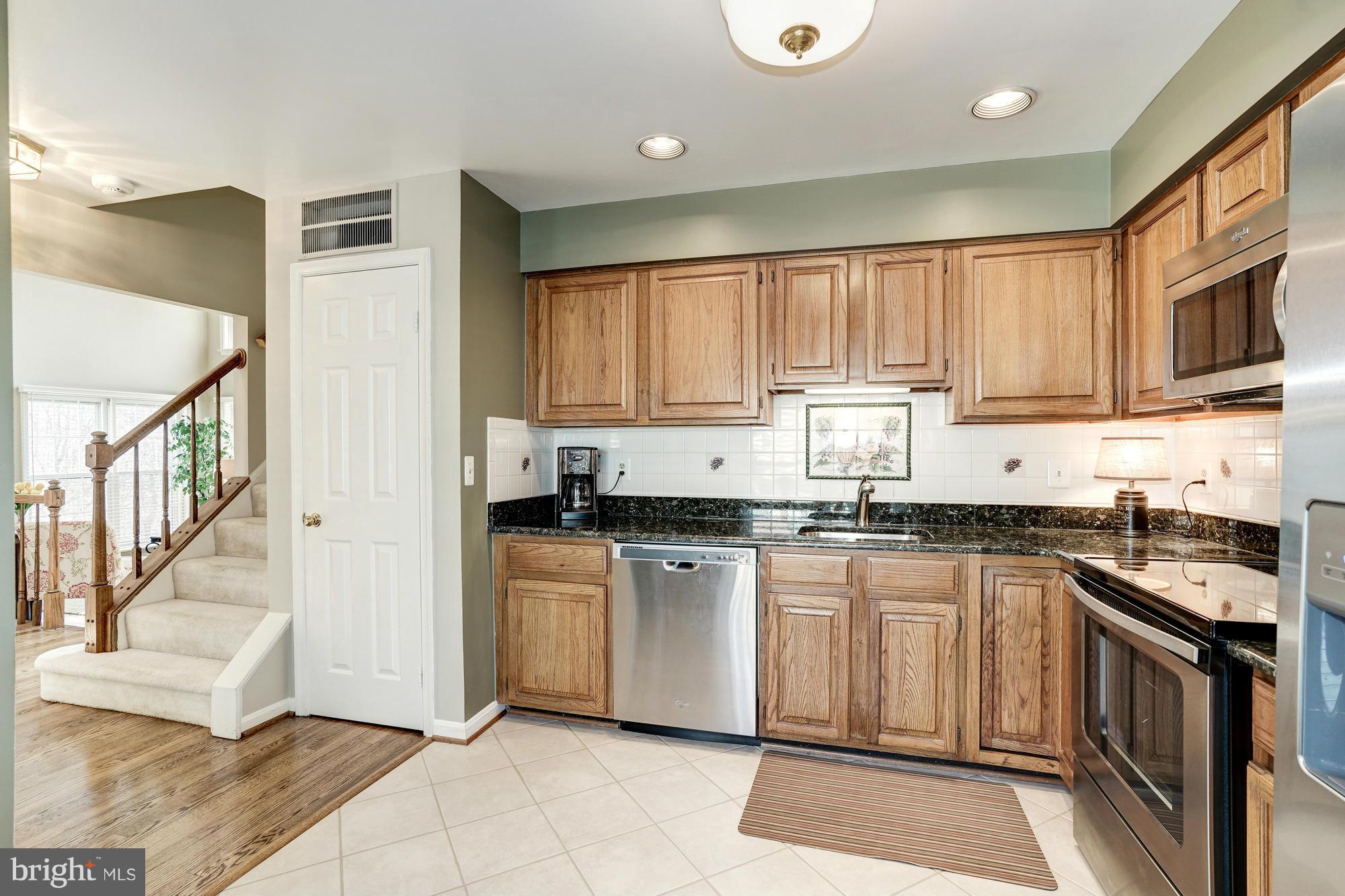 7415 Ridge Oak Court Springfield, VA 22153 - Photo 5 of 30 a kitchen with stainless steel appliances granite countertop a stove a sink and a microwave