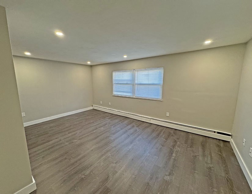 108 Franklin Street Lynn, MA 01902 - Photo 13 of 15 an empty room with wooden floor and windows