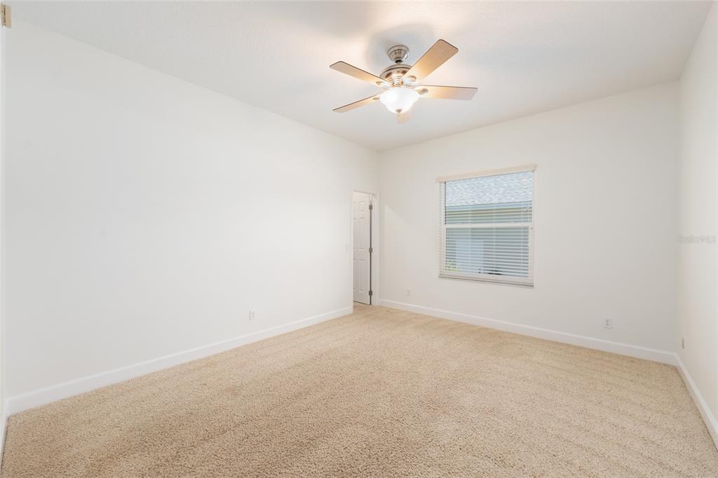 4735 Southeast 112th Street Road Belleview, FL 34420 - Photo 45 of 73 an empty room with a chandelier fan and windows