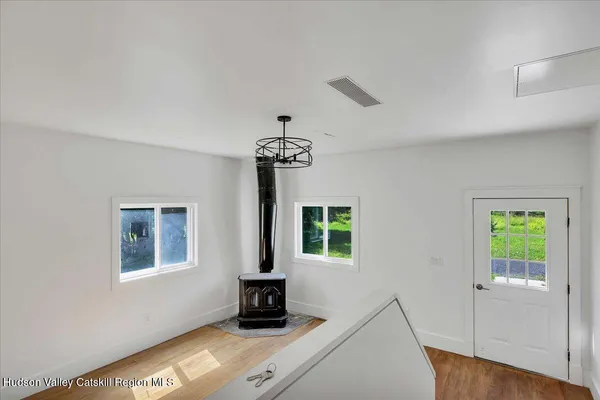a view of an empty room with a window and wooden floor