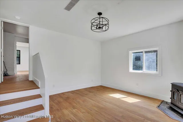 a view of a room with wooden floor and white walls