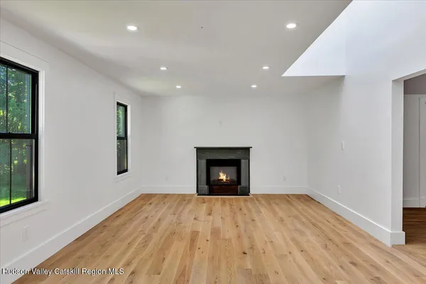 a view of empty room with wooden floor and fireplace