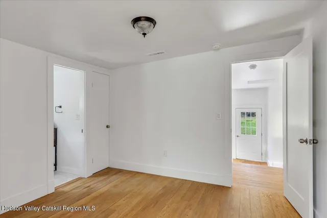 a view of a room with wooden floor and a bathroom