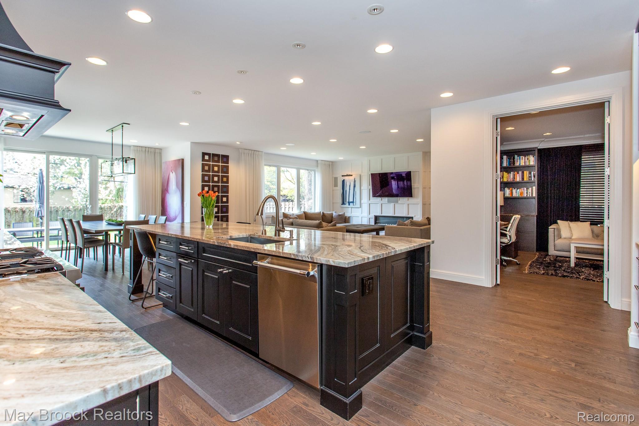 25925 York Road Royal Oak, MI 48067 - Photo 87 of 88 Kitchen featuring light stone counters, open floor plan, an island with sink, dark wood-style flooring, and hanging light fixtures