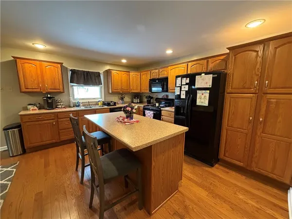 a kitchen with stainless steel appliances sink refrigerator dining table and chairs