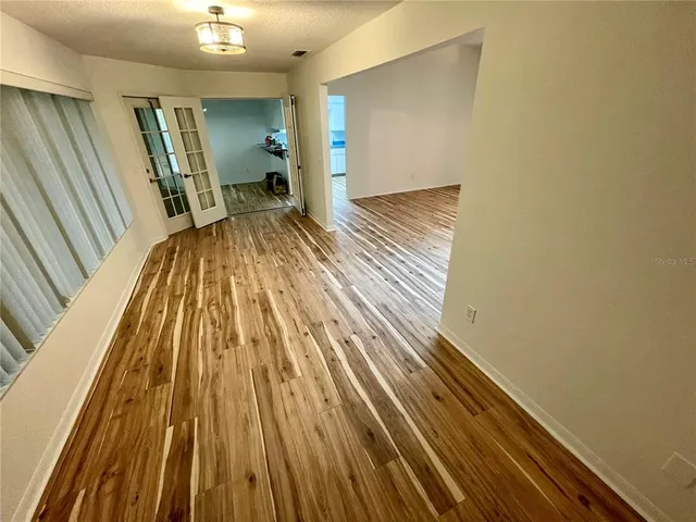 a view of a room with wooden floor