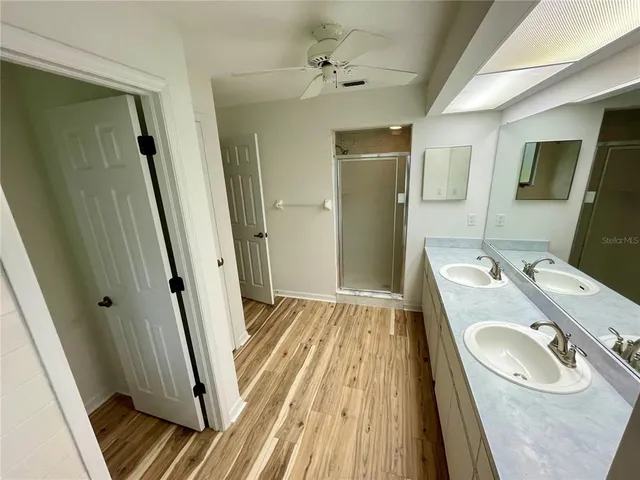 a bathroom with a sink a toilet a mirror and shower