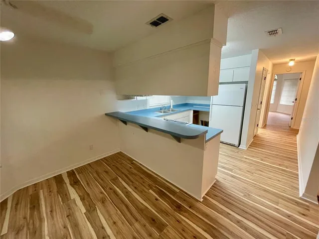 a kitchen view with wooden floor and electronic appliances