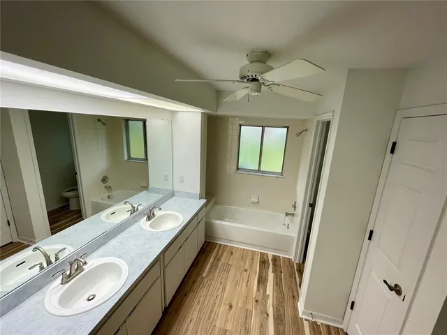 a bathroom with a double vanity sink a mirror and a bathtub