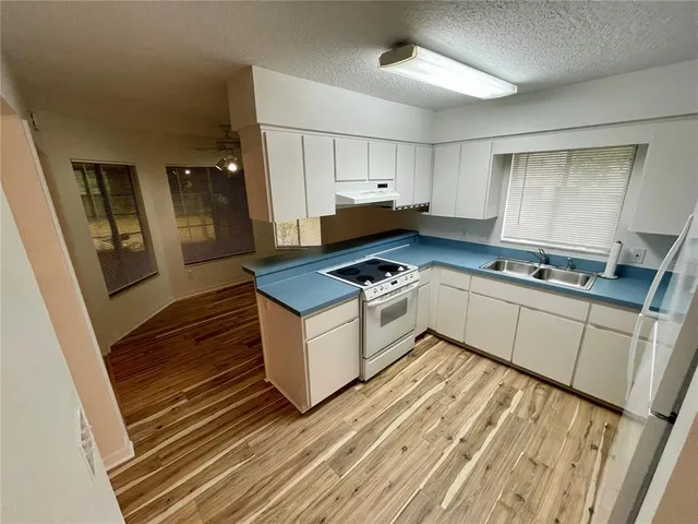 a kitchen with white cabinets and appliances