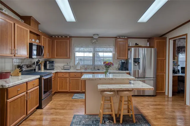 a large kitchen with kitchen island a sink table and chairs