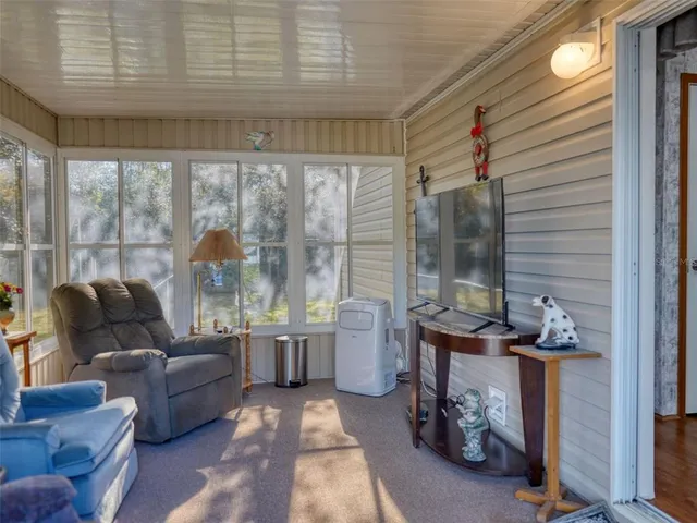 a living room with furniture and a floor to ceiling window