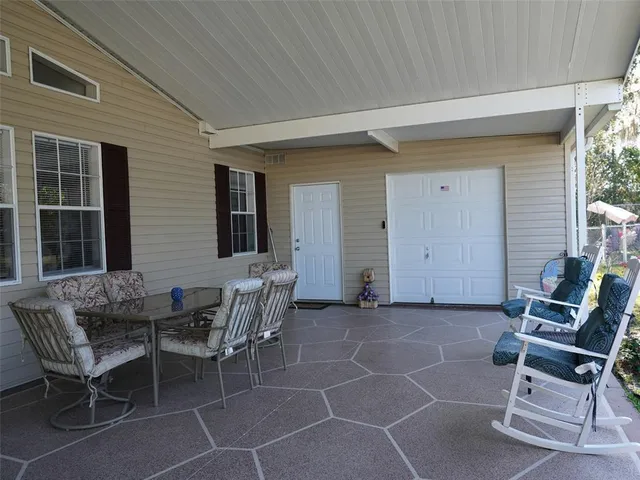 a view of a house with chairs and table in a patio