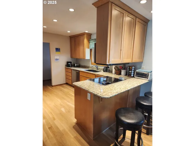 a kitchen with stainless steel appliances granite countertop wooden cabinets a stove a sink and a microwave