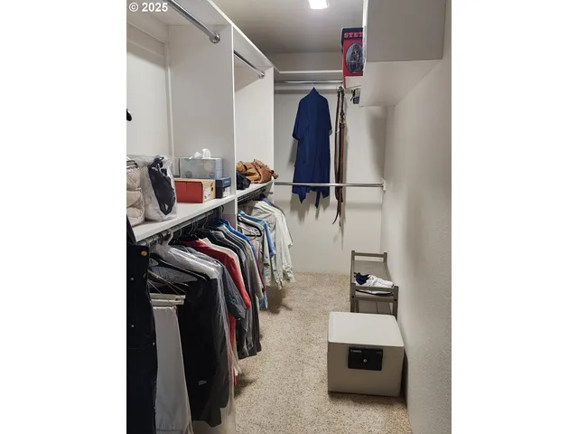 an empty room with a ceiling fan and carpet