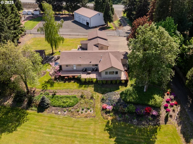 an aerial view of a house with a garden and lake view